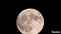 A super moon, known as the Blue Moon, rises next to the 123-story Lotte World Tower in Seoul