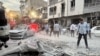 People and first-responders gather outside a building that was hit by an Israeli strike in Tehran on June 13, 2025.