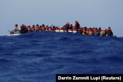 Mintegy 89 migráns egy fából készült csónakban várja a kimentését. A műveletben a Sea-Watch 3 német nem kormányzati migránsmentő hajó és az olasz parti őrség közösen vett részt, mintegy 63 tengeri mérföldre Lampedusa olasz szigettől délre, a Földközi-tenger nyugati részén, 2021. augusztus 2-án