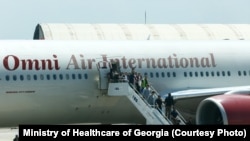 ამერიკიდან დეპორტირებული საქართველოს მოქალაქეები ტოვებენ თვითმფრინავის ბორტს. 31 მაისი, 2025. ფოტოს ჯანდაცვის სამინისტრო ავრცელებს