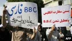 Supporters of Iranian President Mahmud Ahmadinejad hold up placards with slogans against the British media during a rally held in Tehran in June.