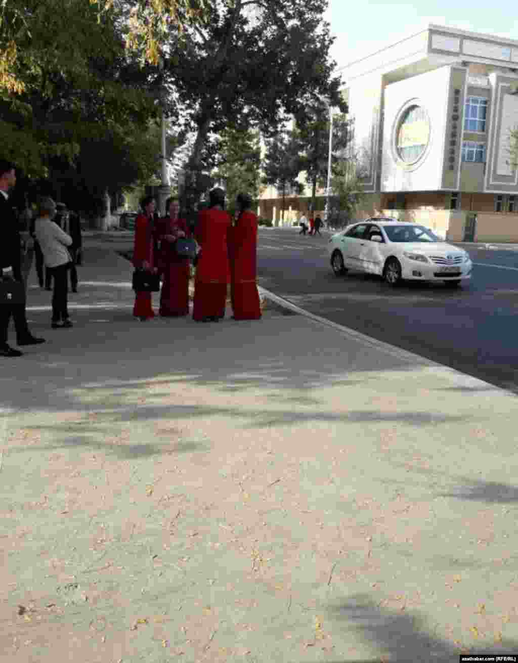 Talyp gyzlar awtobusyň gelmegine garaşýarlar.