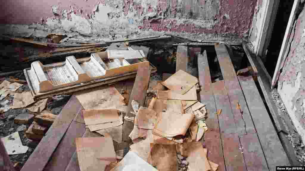 В одном из помещений первого этажа разбросаны старые бухгалтерские документы