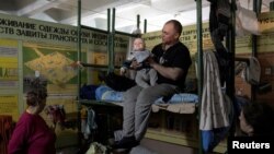 Férfi gyermekével az Azot vegyi üzemben, Szeverodonyeckben 2022. június 12-én