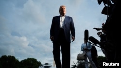 US President Donald Trump looks on as he speaks to press as he arrives on the South Lawn of the White House, May 4
