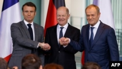 Presidenti francez Emmanuel Macron, kancelari gjerman Olaf Scholz, dhe kryeministri polak Donald Tusk, shtrëngojnë duart gjatë një konference për shtyp në Berlin, 15 mars 2024.