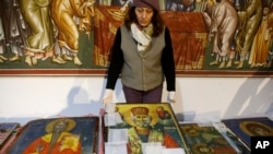 A museum worker displays an icon returned from Albania at the National Museum in Skopje on December 15.
