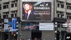 Луѓе поминуваат покрај билборд кој ја пречекува претседателката на Претставничкиот дом на САД, Ненси Пелоси, во Тајпеј, Тајван, среда, 3 август 2022 година.