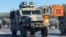 Каляж. Расейскія браняваныя аўтамабілі зь лічбавым кодам 39 на нумарах, які, імаверна, належыць 12-му галоўнаму ўпраўленьню Міністэрства абароны Расеі (яго герб на каляжы). Аэрадром Ліпкі пад Менскам, рэпэтыцыя параду. Фота газэты «Мінская праўда» ад 3 красавіка 2025 году