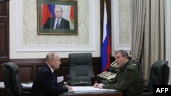 O fotografie distribuită de agenția de stat Sputnik îi arată pe președintele Vladimir Putin și pe Șeful de Stat Major, Valeri Gerasimov, în timpul vizitei președintelui rus la cartierul general militar din Rostov-pe-Don.