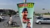 FILE: A cyclist rides past a banner bearing the image of former Inter-Services Intelligence (ISI) Chief Lt. General Zaheerul Islam in Islamabad, April 2014.