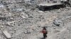 Palestinka prolazi pored ruševina u gradu Gazi, 14. avgusta