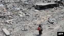 Palestinka prolazi pored ruševina u gradu Gazi, 14. avgusta