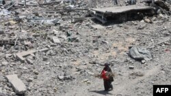 პალესტინელი ქალი შეშის კონით. ქალაქი ღაზა, 14 აგვისტო, 2025.