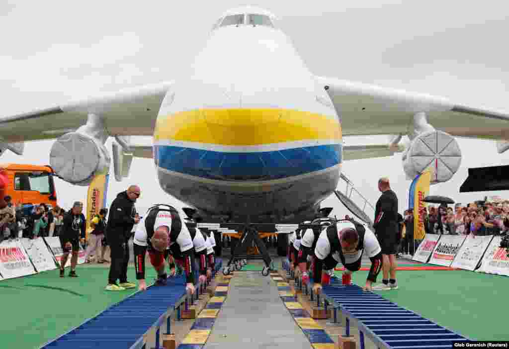Ukrainian strongman athletes set a world record for pulling the world&#39;s largest cargo plane -- an Antonov An-225 -- at an airfield outside Kyiv. Pulling the plane in two groups of four, the men managed to move the plane 4.3 meters within 1 minute and 13 seconds. The feat set a national record for the fewest number of people pulling the plane. In 2013, 10 men pulled the plane.