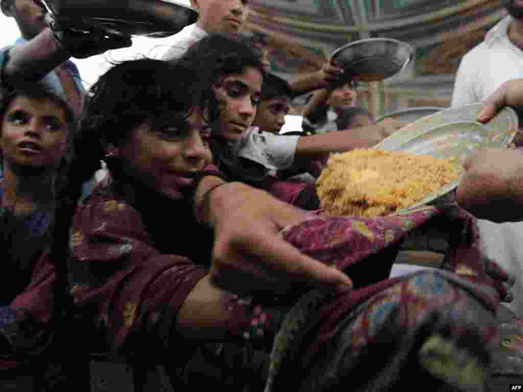 Pakistani children displaced by floods crowd around to receive donated food from a relief camp set up by local volunteers on the outskirts of Sukkur on August 9. Around 13.8 million people have been affected by massive floods in Pakistan, making the scale of the disaster worse than the devastating 2004 tsunami, a UN official said. Photo by Asif Hassan for AFP