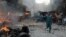 A Pakistani man runs past burning vehicles at the site of a bomb explosion in the busy Kissa Khwani market in Peshawar on September 29.