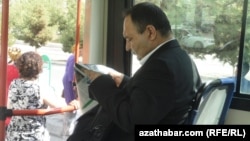 Türkmenistanyň awtobuslarynyň birinde gazet okaýan ýolagçy.