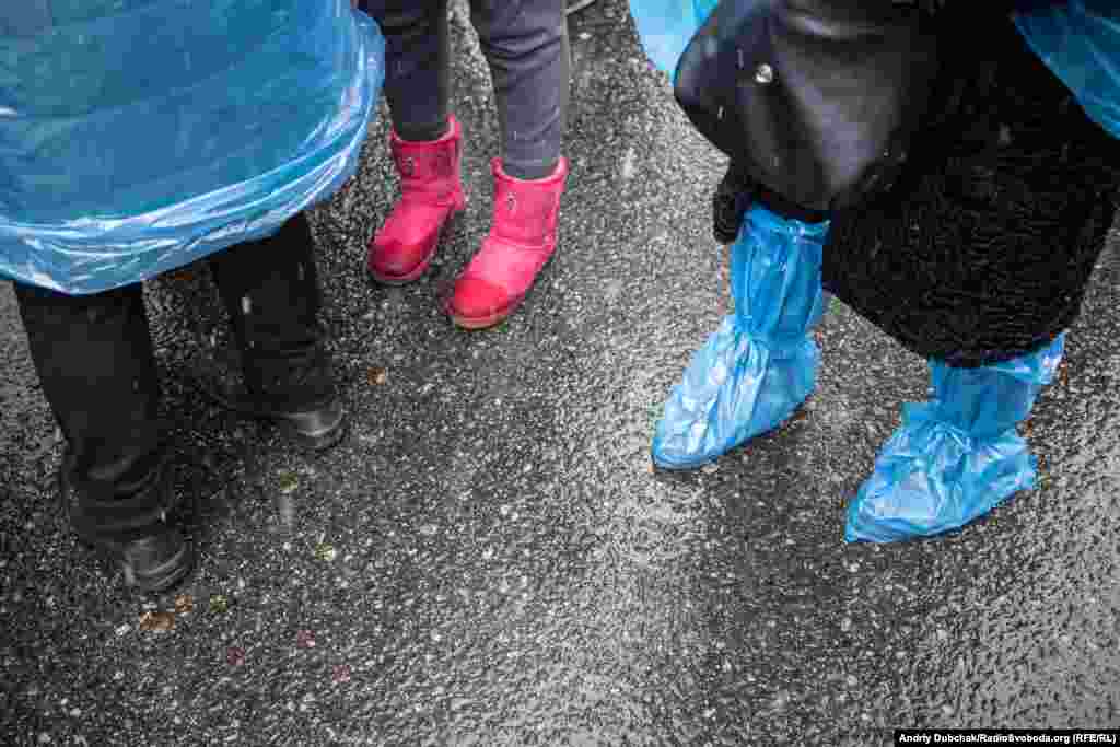 Аби не промокнути, мітингарі вдягнули дощовики, а ноги загорнули в пакети