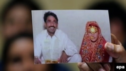 Farzana Parveen's sister Khalida holds up a picture of Farzana during a press conference in Lahore on May 31.