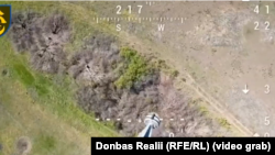 Український дрон-бомбер скидає снаряд на російську піхоту, що сховалась у посадці