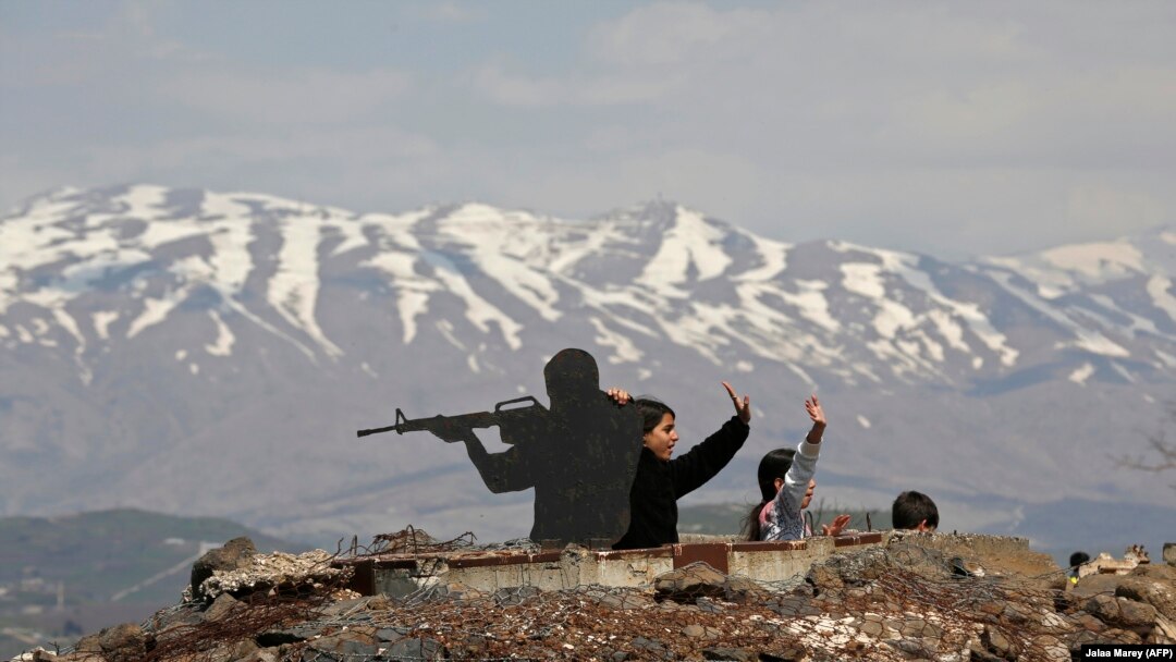 Turiști în aproprierea statuii unui soldat israelian pe muntele Bental în teritoriile anexate de Israel de pe Înălțimile Golan