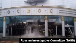 Firefighters work at the Cosmos movie theater's main entrance after an apparent arson attack in Yekaterinburg on September 4.