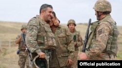 Nagorno-Karabakh -- An Armenian officer hugs a soldier during heavy fihting with Azerbaijani forces along the Karabakh "line of contact," September 28, 2020.