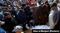 Mourners gather around the body of a demonstrator who was killed at an anti-government protest overnight, during the funeral in Najaf, February 6, 2020