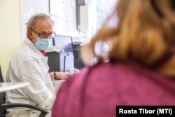 Kincses Zoltán orvos az oltásról tájékoztat egy nőt, mielőtt beoltják az orosz Szputnyik V koronavírus elleni vakcina második adagjával a Békés Megyei Központi Kórház Dr. Réthy Pál Tagkórház egyik oltópontján Békéscsabán 2021. június 7-én