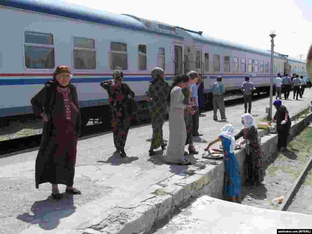 Ýolagçylar gutap, somsa, fitçi satyn alýarlar. Aşgabat-Mary otly gatnawynyň ugrundaky Duşak stansiýasy.