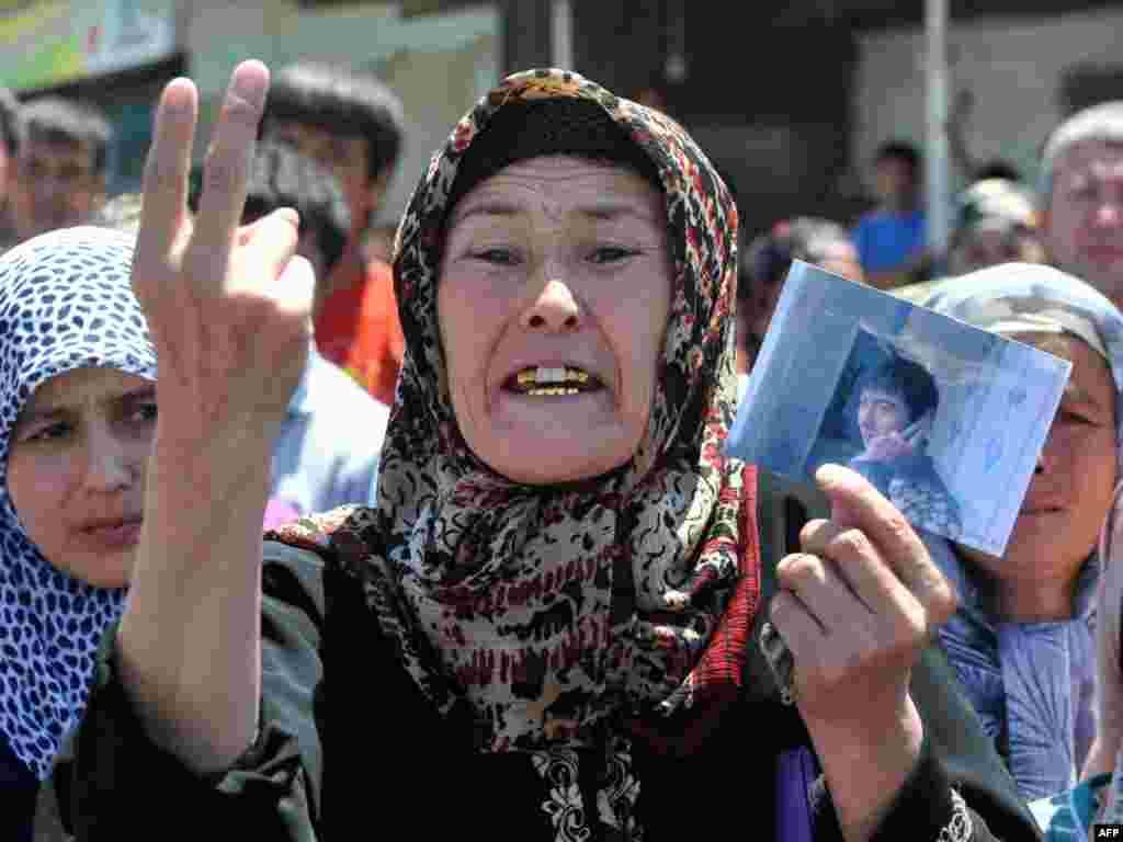 Узбечка плачет и держит в руках фотографию убитого родственника. 20 июня 2010 года.