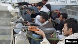 Yemeni tribesmen take positions on a street near the house of tribal leader Shiekh Sadiq al-Ahmar during clashes with police in Sanaa on May 24.