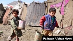 Internally displaced children carry water in Kabul. Many Afghans have no access to basic services like running water and electricity.