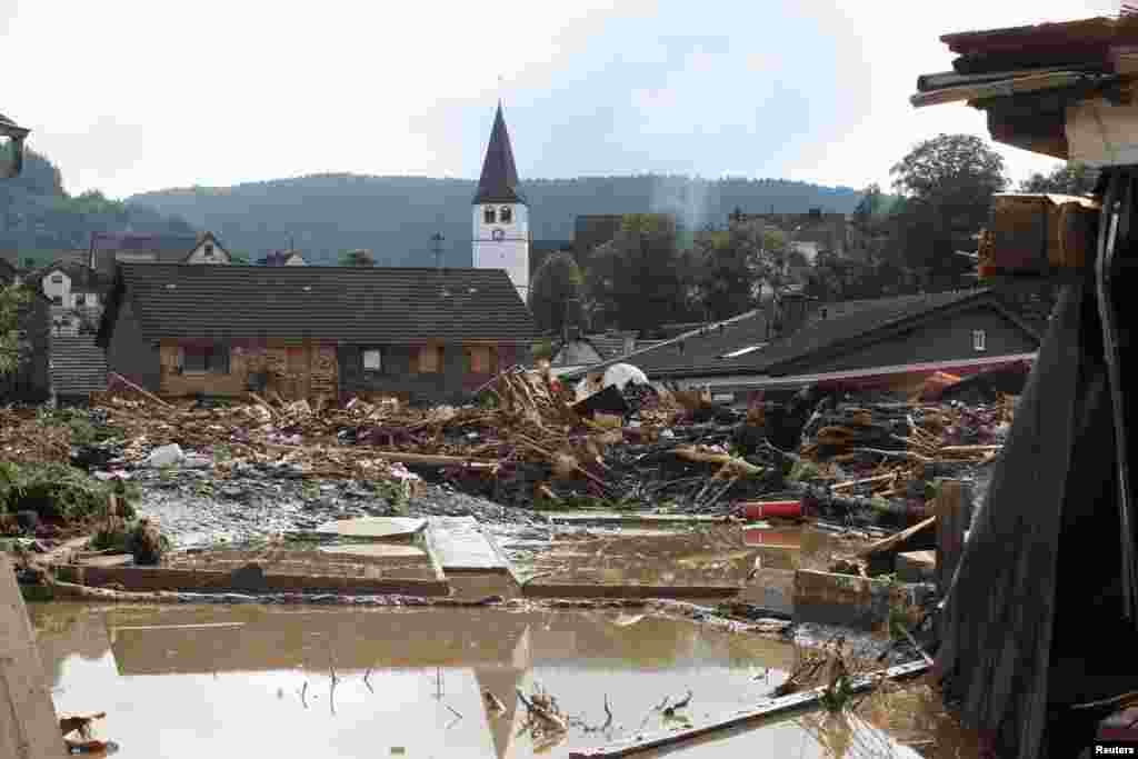 Több ház is összedőlt az árvízben. A német meteorológiai szolgálat szerint továbbra is több térségben heves esőzések várhatók.