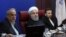 Iranian President Hassan Rohani (C) sits next to Minister of Economy during a meeting with members of the ministry, in Tehran, January 8, 2018