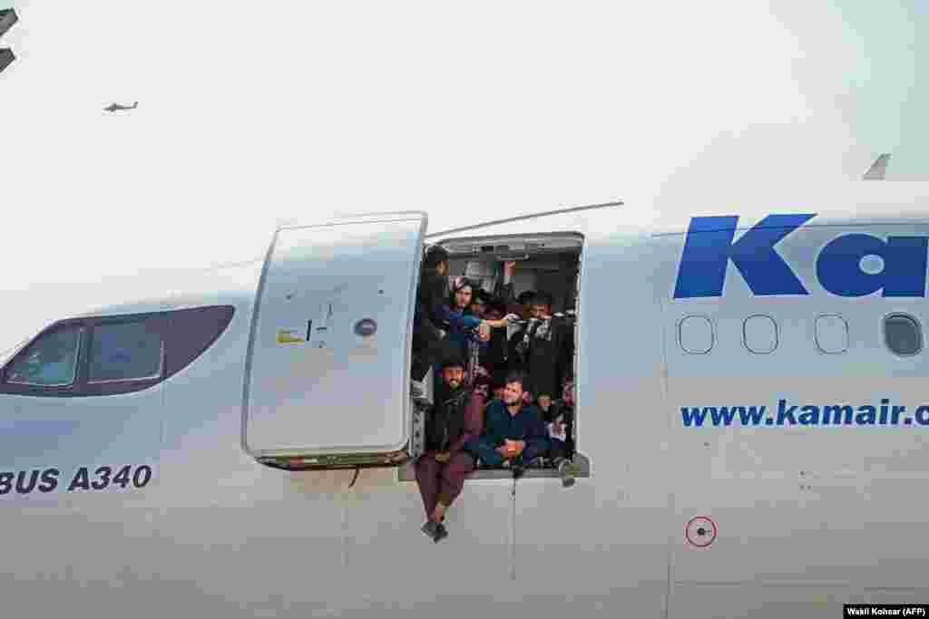 Отчаявшиеся афганцы втиснулись в самолет в аэропорту Кабула 16 августа, пытаясь бежать из страны после захвата власти талибами