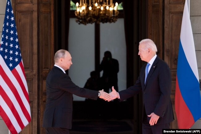 Vladimir Putin shakes hands with U.S. President Joe Biden prior to a summit in Geneva on June 16.