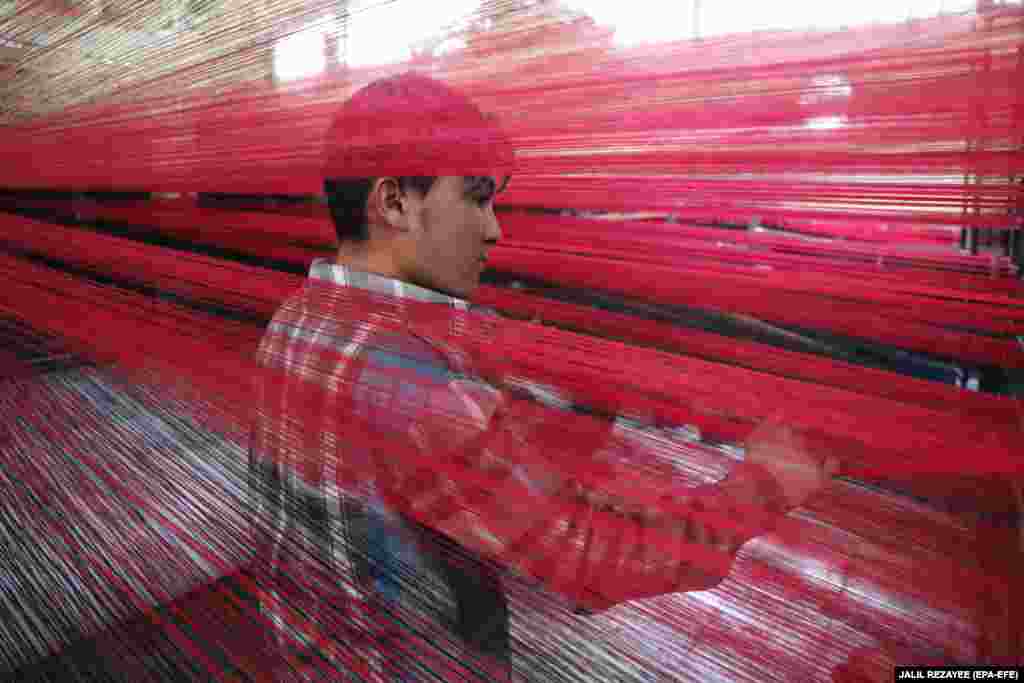 An Afghan worker checks lines of thread at a carpet factory in Herat. (epa-EFE/Jalil Rezayee)