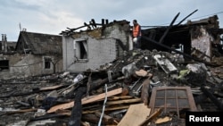 A volunteer inspects the aftermath of a Russian missile strike overnight on a residential area in Zaporizhzhya. 