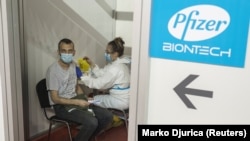 Egy férfi megkapja a koronavírus elleni Pfizer-BioNTech vakcina második adagját Belgrádban, 2021. április 13-án