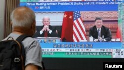 Un bărbat din Hong Kong urmărește, pe un ecran din Hong Kong, știrile despre convorbirea dintre Joe Biden și Xi Jinping. A fost a cincea discuție a celo doi în calitate de președinți și prima după cea din martie, de la scurt timp după invazia Rusiei în Ucraina.