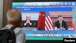 O discuție între președintele Chinei, Xi Jinping, și omologul său american, Joe Biden, difuzată pe un ecran într-un centru comercial din Hong Kong