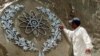 A worker in Islamabad cleans a bas-relief of the Chaghi Mountains, where Pakistan conducted its atomic explosions in 1998.