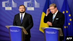 Ukrainian Deputy Prime Minister Serhiy Arbuzov (left) and European Commissioner for Enlargement and European Neighborhood Policy Stefan Fuele appear at a joint press conference in Brussels on December 12.