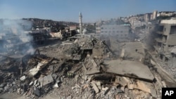 Hezbollah rescue workers (lower center) stand amid the rubble of buildings hit overnight by Israeli air strikes, in Nabatiyeh, south Lebanon, on October 13.