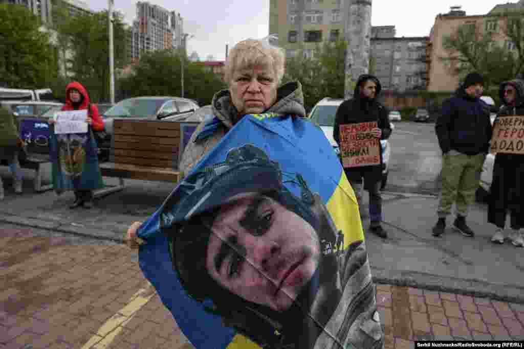 Тамара тримає український прапор, на якому зображено фото її сина Олексія, який зник безвісти