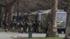 Russian soldiers stand next to their trucks during a rally against Russian occupation in Kherson on March 7.