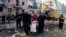 People carry a casualty as emergency services work to rescue residents from under the debris at the site of an apartment building hit by a Russian missile strike in the town of Pryluky, in Ukraine's Chernihiv region on October 7.