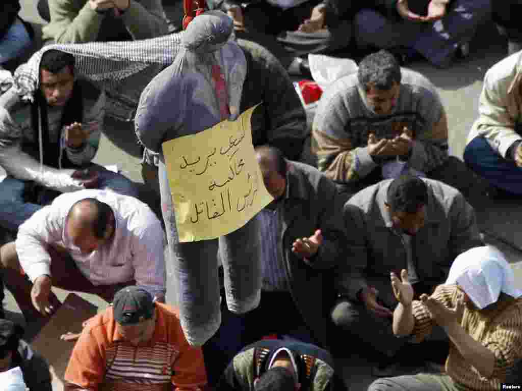 Antigovernment protesters take part in Friday Prayers next to an effigy of President Hosni Mubarak on Tahrir Square in Cairo on February 4. The sign reads, "We want to put the murderous president on trial." Photo by Amr Abdallah Dalsh for Reuters